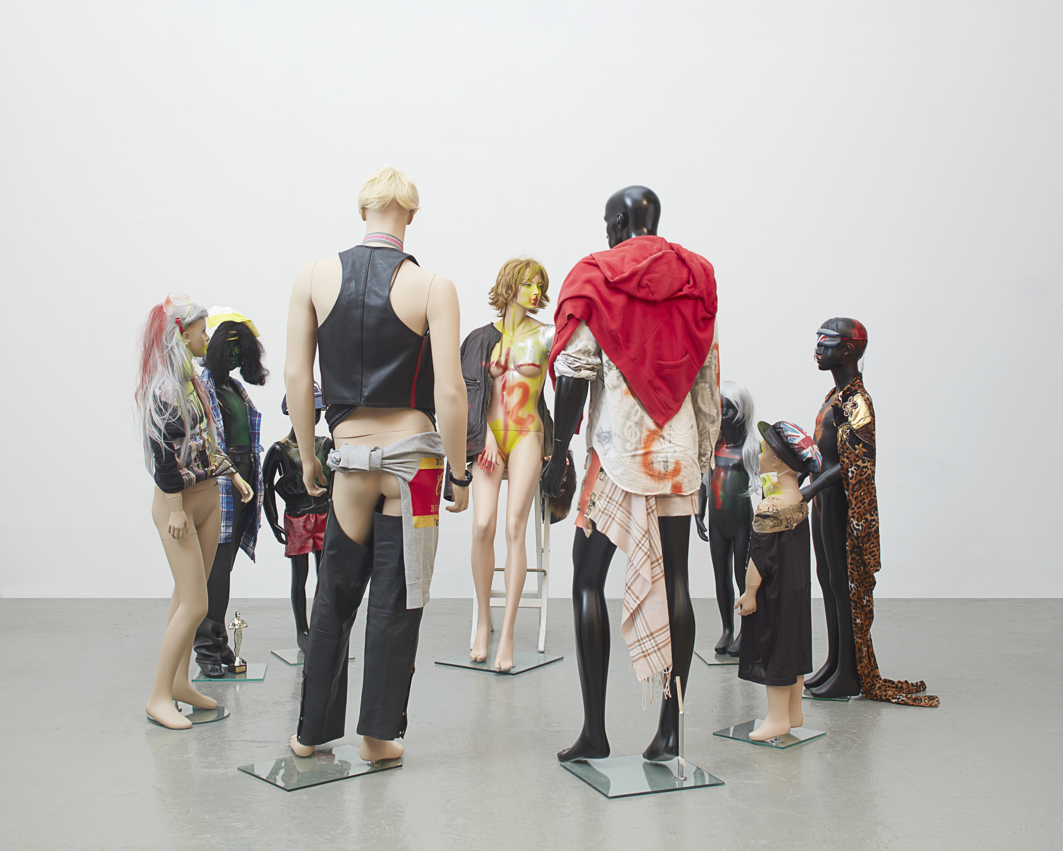 Isa Genzken (*1948) Schauspieler, 2016 9 Schaufensterpuppen, Mischtechnik, Stoff, Leder, Perücken, Lack, Klebeband, Holzhocker, Glas 192 x 242 x 236 cm Courtesy Galerie Buchholz © VG Bild-Kunst, Bonn 2025